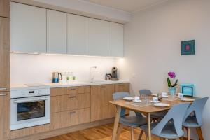 a kitchen and dining room with a table and chairs at HARAKA APARTMENT WITH SUNSET BALCONY in Tartu