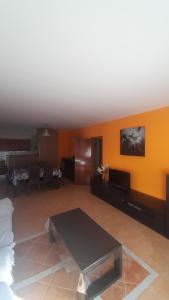 リウマルにあるVilla Mendozaのオレンジ色の壁のリビングルーム(テーブル付)