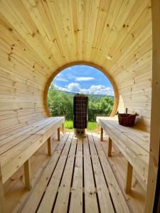 uma vista interior para uma sauna de madeira com dois bancos em Czill-Lokum- klimatyczna chata w Beskidach em Maków Podhalański