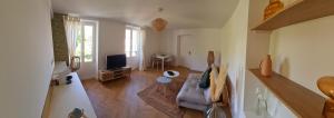 sala de estar con sofá y TV en L'App'Art d'Auvers, en Auvers-sur-Oise