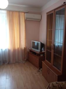 a living room with a tv and a dresser with a tvicterictericter at Квартира Гудоу in Gudauta