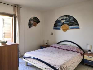 カステルサルドにあるAppartamento Calamarinaのベッドルーム1室(ベッド1台付)が備わります。壁には絵画が飾られています。