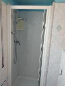 een douche met een glazen deur in de badkamer bij L'appartamento delle vacanze in Venturina Terme