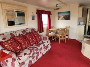 a living room with a couch and a table at 6 Berth Seaview Ingoldmells Park Lodge in Ingoldmells