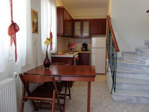 a small kitchen with a wooden table and a staircase at Villa Sofia Fanari in Fanari