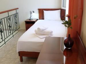 a bedroom with a bed with white sheets and a vase at Villa Sofia Fanari in Fanari