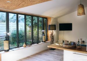 sala de estar con ventanas, mesa y TV en Chrysalide cocon, en Nantes