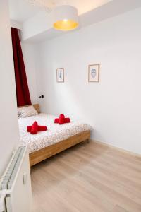 Un dormitorio con una cama con almohadas rojas. en Les Cerisiers - Appart de Standing à Namur Centre en Namur