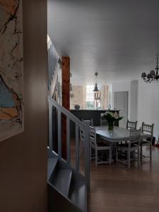 a dining room and kitchen with a table and a staircase at L'Appartement de la MAISON BLEUE in Villeréal