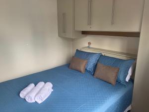a bed with two towels on top of it at Apto próximo aos pontos turísticos e restaurantes in Gramado