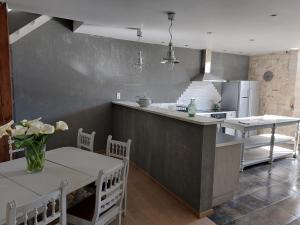 a kitchen with a counter and a table and a kitchen with a counter at L'Appartement de la MAISON BLEUE in Villeréal