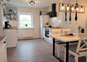 a kitchen with a table and a dining room at Naturnahe FeWo zwischen Meer&Seen bei Kiel in Schwentinental