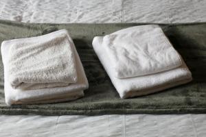 two towels sitting on top of a bed at Spacious 3-Bed Apartment for Small Large Groups Close to BBC SSE Central Glasgow West End Free Parking in Glasgow