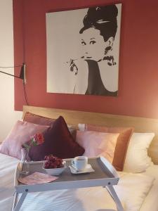 ミュンヘンにあるパレオ ファイネスト サービスド アパートメンツのベッドの上にテーブルと食料品のトレイ