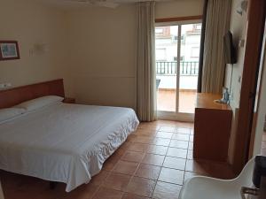 um quarto com uma cama e uma porta de vidro deslizante em Hotel Marycielo em Sanxenxo