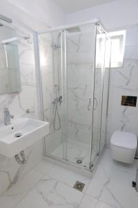 a bathroom with a shower, toilet and sink at Hotel Piccolino in Sarandë