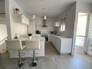 eine Küche mit weißen Schränken sowie einem Tisch und Stühlen in der Unterkunft Centre Apartment near Plaza de Toros in Alicante