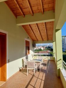un patio con tavolo e sedie sul balcone. di GreenVilla Park a Durrës