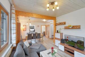 ein Wohnzimmer mit einem Sofa und einem Esszimmer in der Unterkunft Seepark Kirchheim Ferienhaus bei Nina mit Sauna in Kirchheim