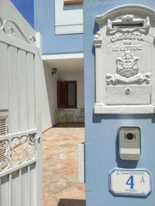 un edificio blu con un cancello e un cartello sopra di Il Faro a Porto Torres