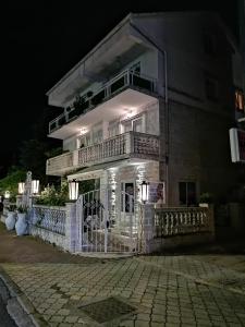 a large white building with a balcony at night at Romana 1 in Tivat
