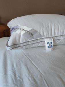 Una almohada con la palabra sueño en ella sentada en una cama en Stelios Rooms, en Palaiochóra