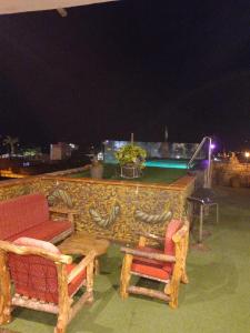 a patio with two chairs and a table and a pool at Castillo de Tarapoto in Tarapoto