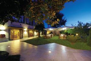 une maison avec une terrasse dotée de tables et de chaises dans l'établissement Pisani Hotel, à San Nicola La Strada