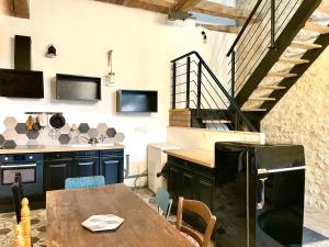 a kitchen with a wooden table and a staircase at CAPORIZON-La Grange-Le Clos de Chambord in Saint-Claude-de-Diray