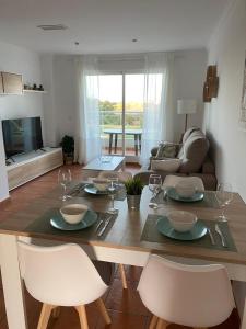 ein Wohnzimmer mit einem Tisch mit Stühlen und einem Esszimmer in der Unterkunft Blue Oliva Nova MET & Golf in Oliva