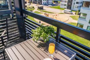 a bench on a balcony with a drink on it at HARAKA APARTMENT WITH SUNSET BALCONY in Tartu