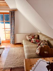 a living room with a couch with pillows on it at Bio-Bauernhof Anawander in Mariahof