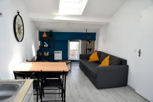uma sala de estar com um sofá e uma mesa em Appartement "Sacha" au calme en Hypercentre de Revel em Revel