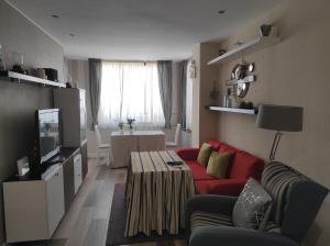 トレモリノスにあるLa Colina - Playamar Apartamentoの赤いソファとテレビのあるリビングルーム