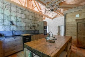 uma cozinha com um balcão de madeira e um lavatório em Manoir de la Mazeraie lodge de luxe Loire Valley em Joué-lés-Tours