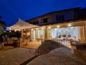 a building with a patio with tables and chairs at night at Eco Hotel Montemerlo in Fetovaia