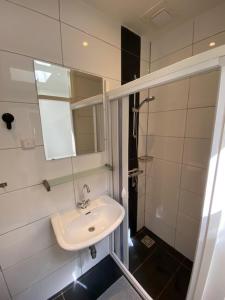 a bathroom with a sink and a shower with a mirror at Strandhuisje Ermerzand in Erm +26 photos
