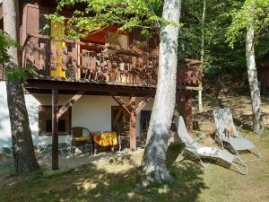 una casa con un balcón con sillas y un árbol en Holiday home Zajícovi, en Rabyně