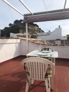 a table with wine glasses and an umbrella on a roof at Casa Quimeres in Denia