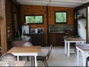 una cucina con tavoli e sedie in legno in una stanza di Affittacamere Soleluna a Castiadas