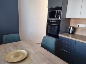 a small kitchen with a wooden table and a microwave at BIVIO apartment Dolná in Banská Štiavnica +11 photos
