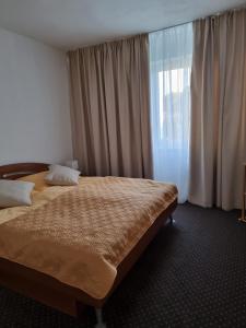 a bedroom with a bed and a large window at BIVIO apartment Dolná in Banská Štiavnica