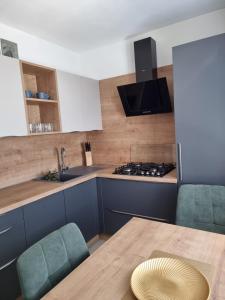 a kitchen with a table and chairs and a sink at BIVIO apartment Dolná in Banská Štiavnica
