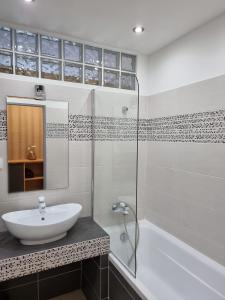 y baño con lavabo, ducha y bañera. en BIVIO apartment Dolná, en Banská Štiavnica
