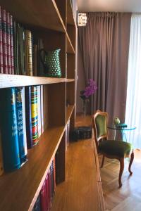 a book shelf with books and a chair in a room at Luxury Spalato Garden in Split
