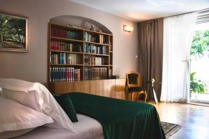 Luxury Spalato Garden في سبليت: غرفة نوم مع رف للكتب مليئ بالكتب