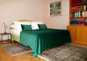 a green bed in a room with a book shelf at Luxury Spalato Garden in Split