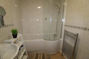Baño blanco con bañera y lavamanos en Aspley House en Sutton in Ashfield