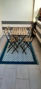 - une table de pique-nique et des chaises sur un tapis à un étage dans l'établissement Appartement avec terrasse, à Toulon