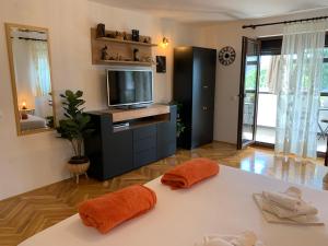 a living room with a tv and a table with towels at Puntižela-Patty in Pula